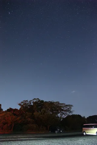 星降る夜、静かに佇む車と森