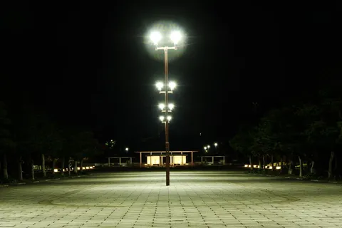 夜の広場に立つ光の柱