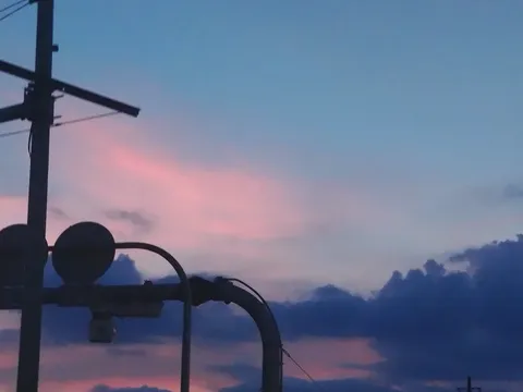 夕暮れ、都会の空に灯るピンク