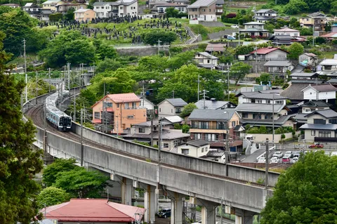 坂を駆け上がる列車と住宅街