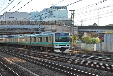 線路を走る緑の列車の風景