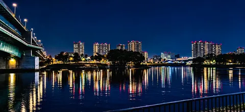 夜の水辺に映る都市灯