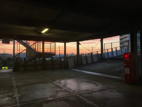 駐車場の赤ランプ、夕焼け空への灯台