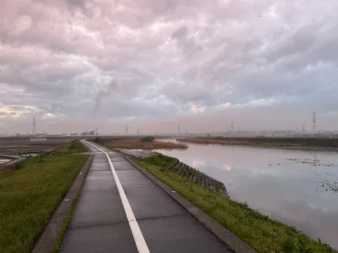 川沿いの道、夕暮れの産業風景
