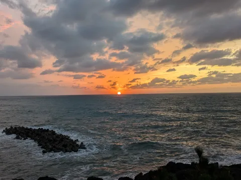 水平線に沈む夕陽と波