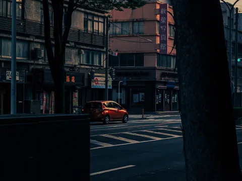 夕暮れの街角、オレンジの車
