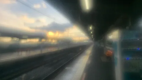 霧のホームに沈む夕暮れ