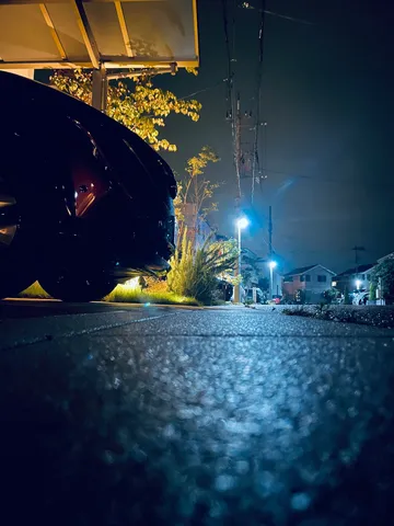 雨上がりの夜、車のライトが照らす日常