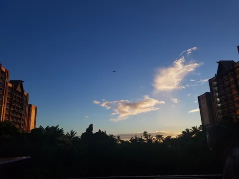 飛行機雲と夕暮れのビル群