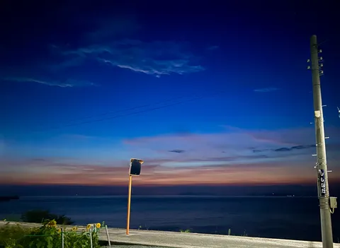 宵の色に染まる海辺の道