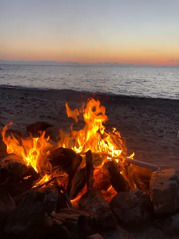 夕暮れのビーチで、焚き火と静かな波音