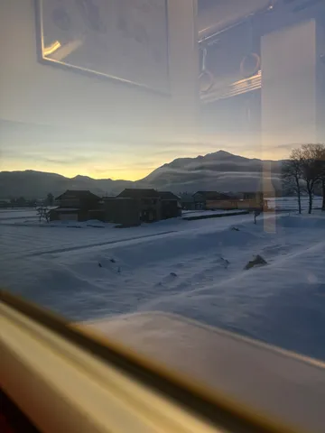 雪原に佇む山、朝焼けの光