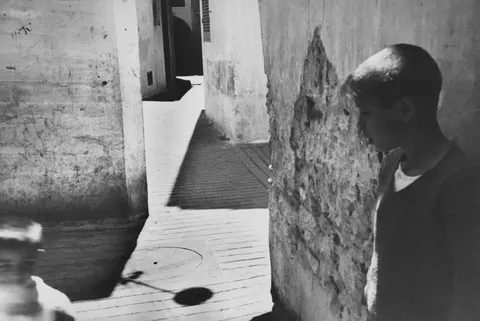路地の少年、光と影の交差点
