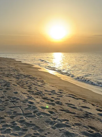 足跡残る、夕陽の海岸線
