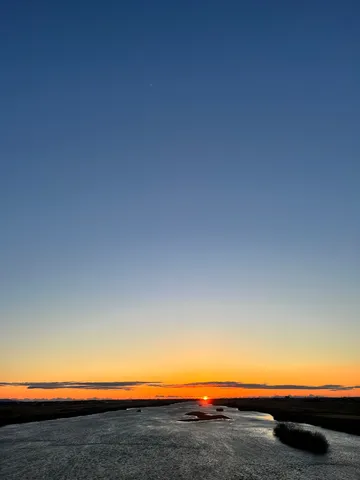 茜色に染まる水辺の道