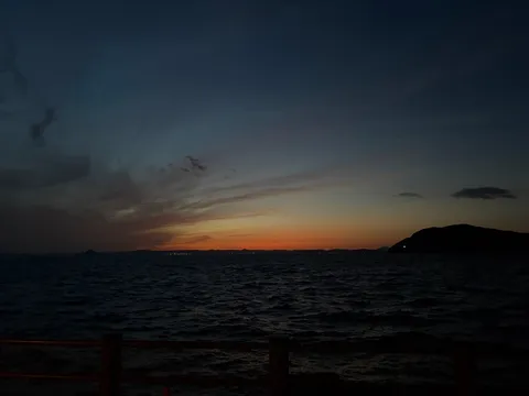 夕暮れの水平線に灯る光