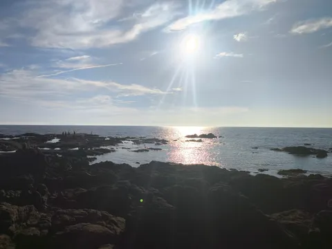 岩場の海辺、陽光と水面