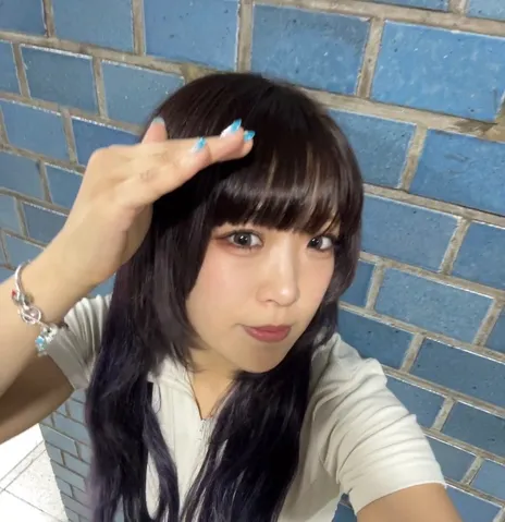 何気ない仕草と青い壁