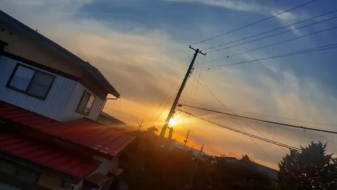 傾ぐ電柱と茜色の空