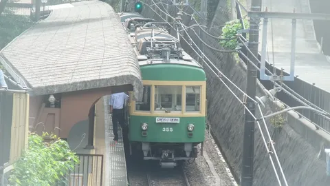 緑の列車と石垣のコントラスト