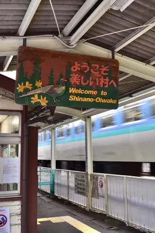 美しい村への歓迎看板と列車