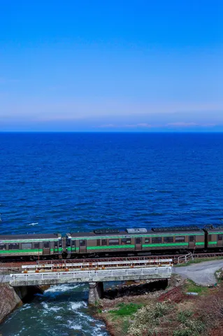 海沿いを走る緑の電車