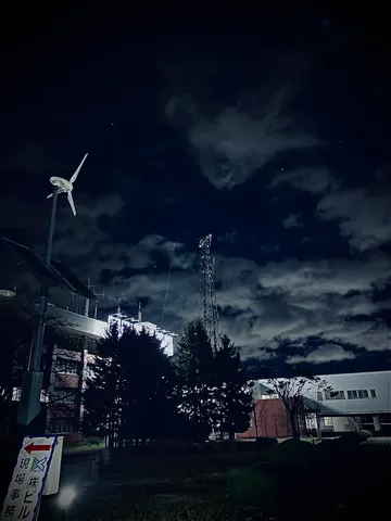 夜空に立つ風車と通信塔