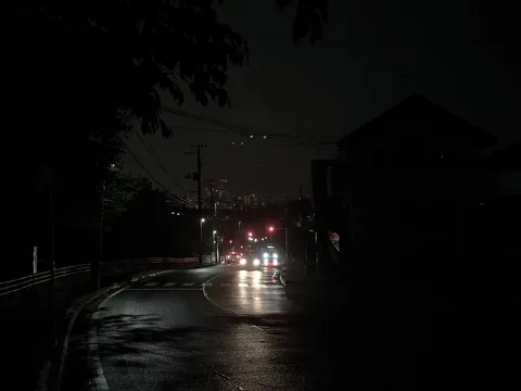 夜の雨道に灯る反射