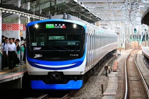 都会の風景に溶け込む列車