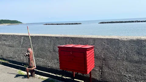 潮風と赤い郵便ポスト、夏の海辺