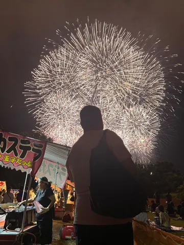屋台の熱気と夜空の花火