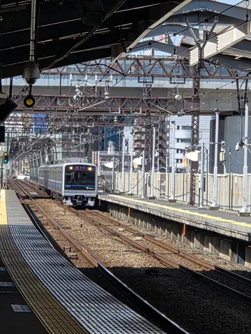 都会の駅に滑り込む銀の列車