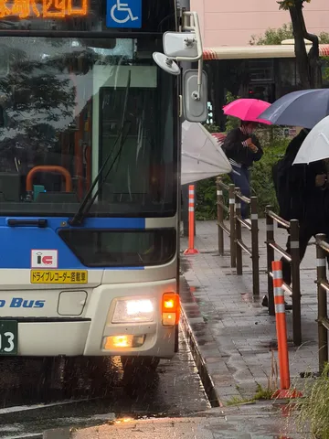雨のバスと傘の列
