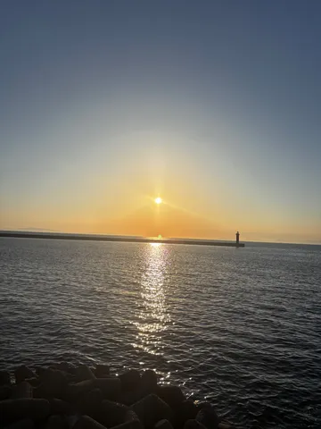 灯台が灯す、水平線に沈む夕日