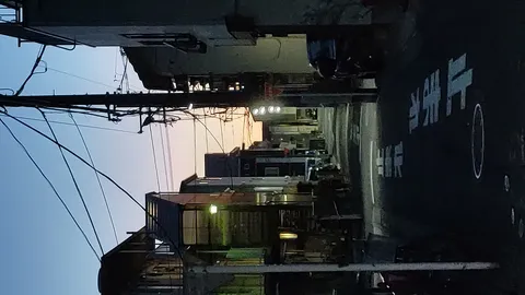電線が交差する夕暮れ路地