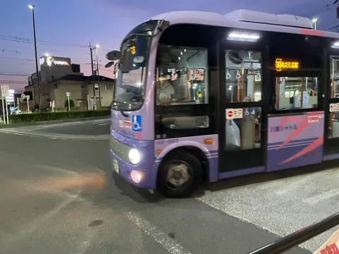 夕暮れ時、紫色のバスが走る