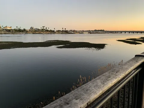 水面に映る夕空と遠くの橋