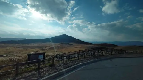 青空と山、風にそよぐ草の道