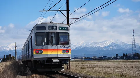 雪山バックのローカル線