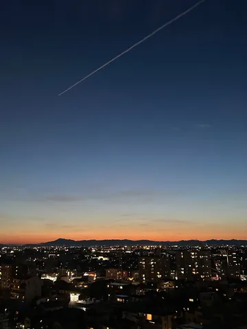 夜景に伸びる飛行機雲