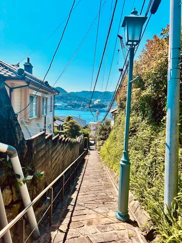 坂道の先に広がる港町の青い空