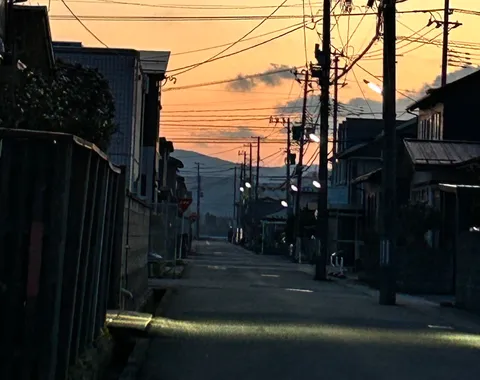 夕暮れの街角、灯りが灯る道