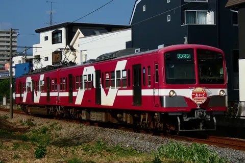 信号色に映える、都会を駆ける赤い電車
