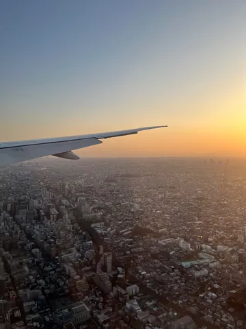 夕暮れ、街並みと飛行機雲