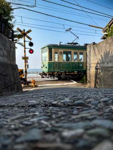 踏切の向こうに広がる海と電車