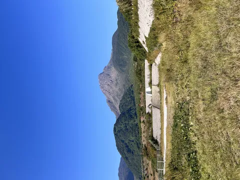 青空の下、雄大な山と構造物