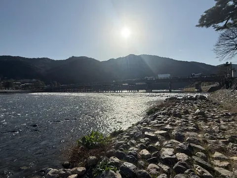雄大な山を背景に穏やかな川面を渡る風