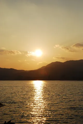 夕陽に染まる湖面と山々