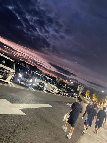 夕暮れの駐車場の群像