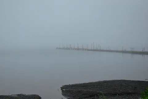 霧の岸辺に浮かぶ桟橋の影